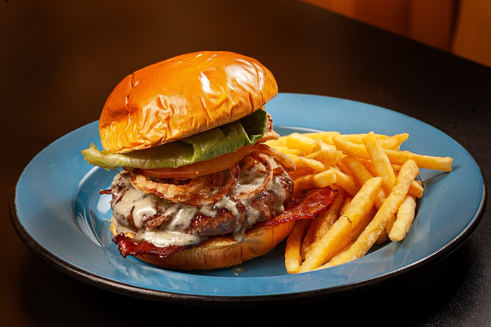 Hambúrguer artesanal do Ney Burguer com bacon, cebola crispy e batata frita
