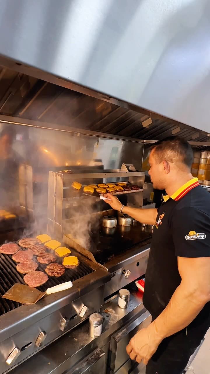 Ney na chapa preparando os burgers